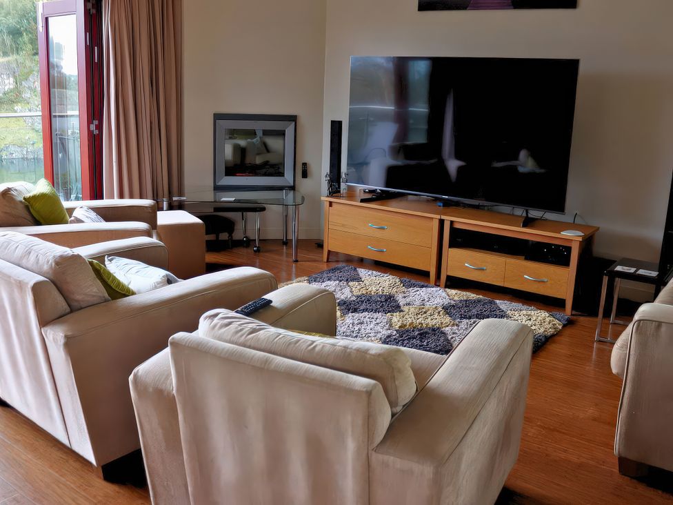 A living room with a sofa set and television at Boavista in Carnforth