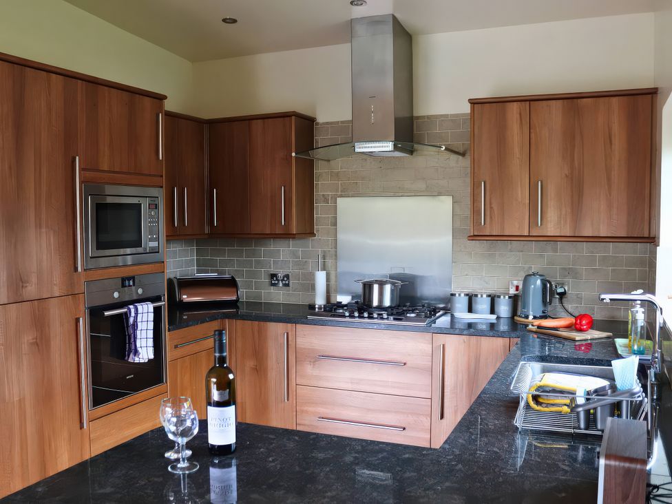 A kitchen with cabinets, countertop, stove, and appliances at Boavista in Carnforth