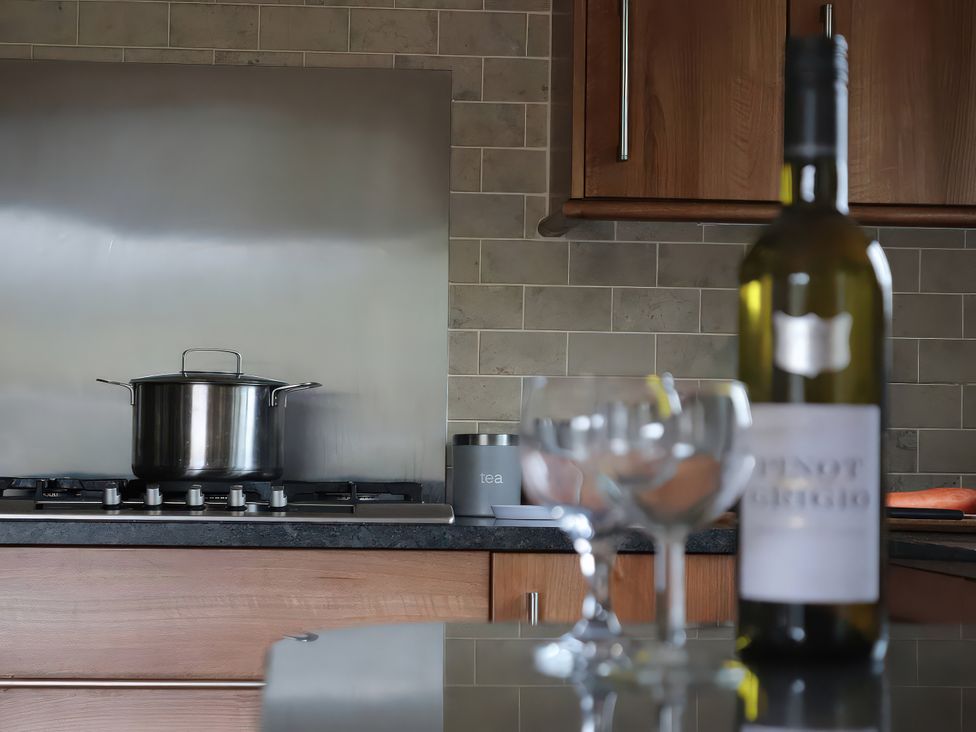 A kitchen with a pot on the stove and a wine bottle on the counter at Boavista in Carnforth