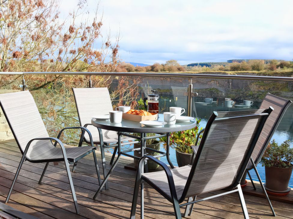 A deck with chairs and a table set for tea at Boavista in Carnforth