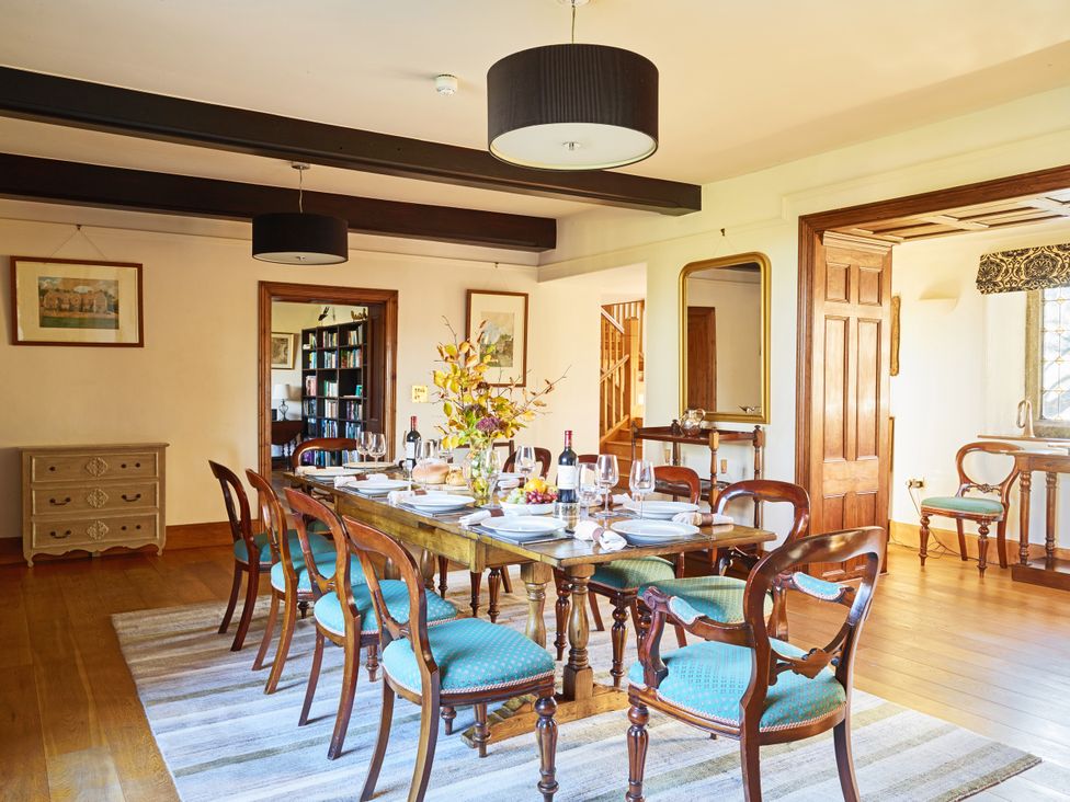A dining room with a table set for dinner at Great Bidlake Manor in Bridestowe near Lydford