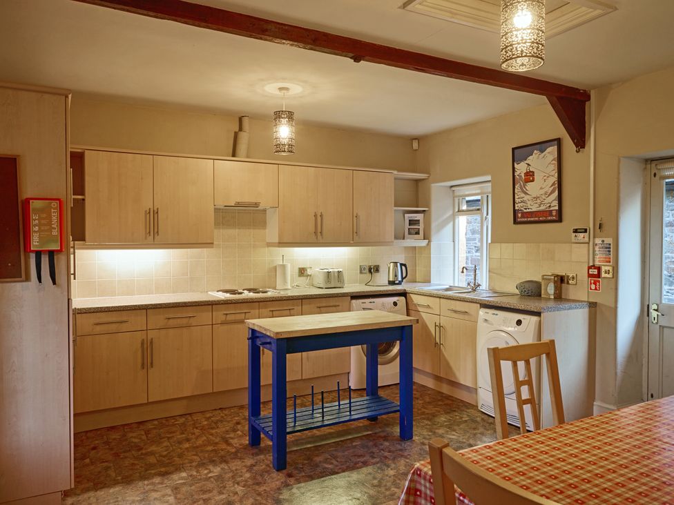 A kitchen with cabinets, sink, and table at Great Bidlake Manor, Bridestowe, near Lydford