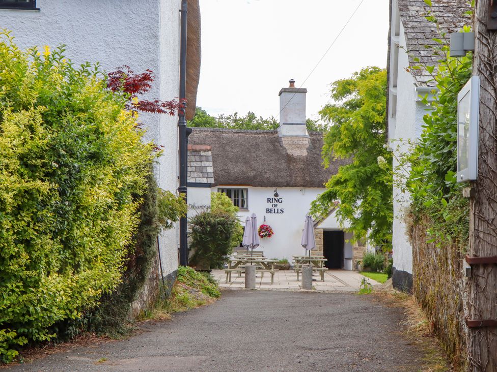 An outdoor area with benches and a sign at Ring of Bells in North Bovey