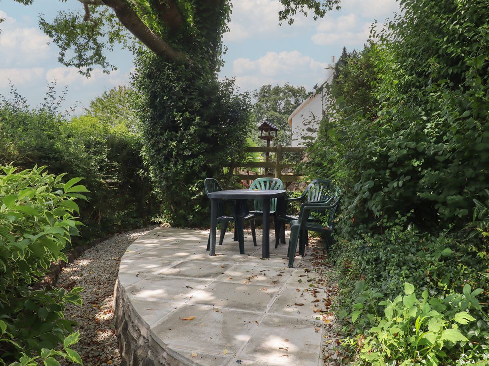 A garden with a table and chairs at Little Gate Cottage in North Bovey
