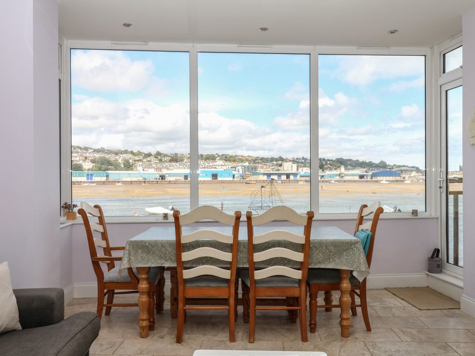 A dining room with a table and chairs overlooking the coast at The Dolphins in Shaldon