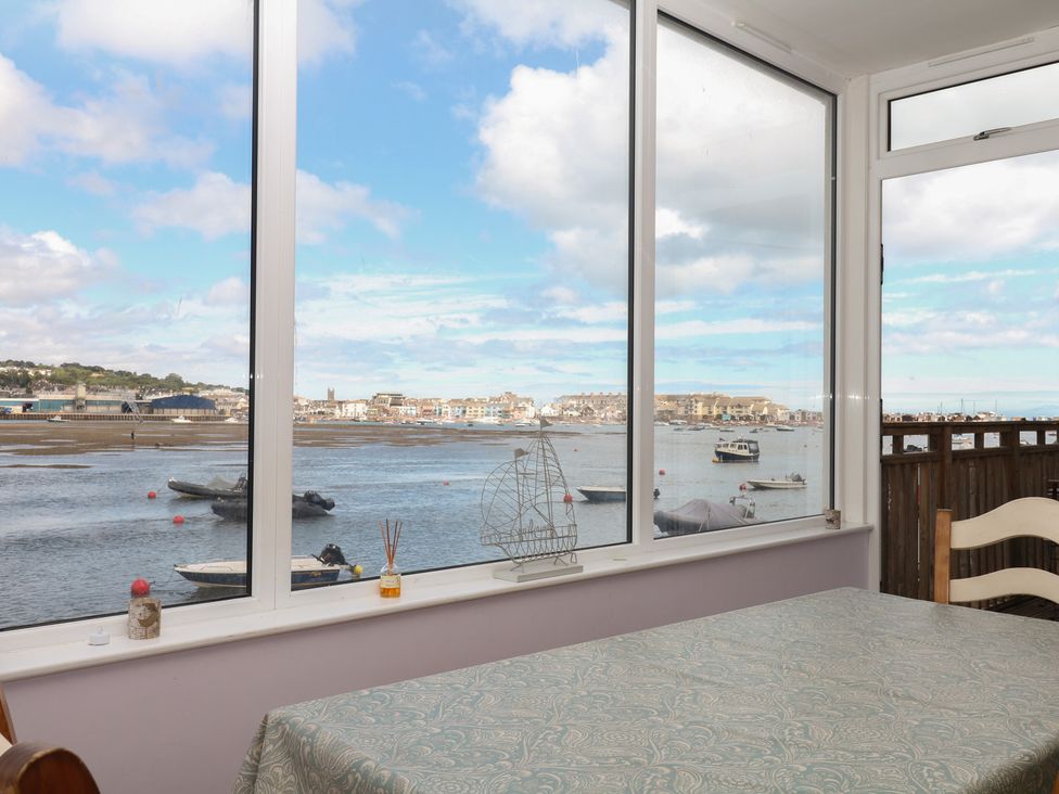 A conservatory with a view of the water and boats at The Dolphins in Shaldon