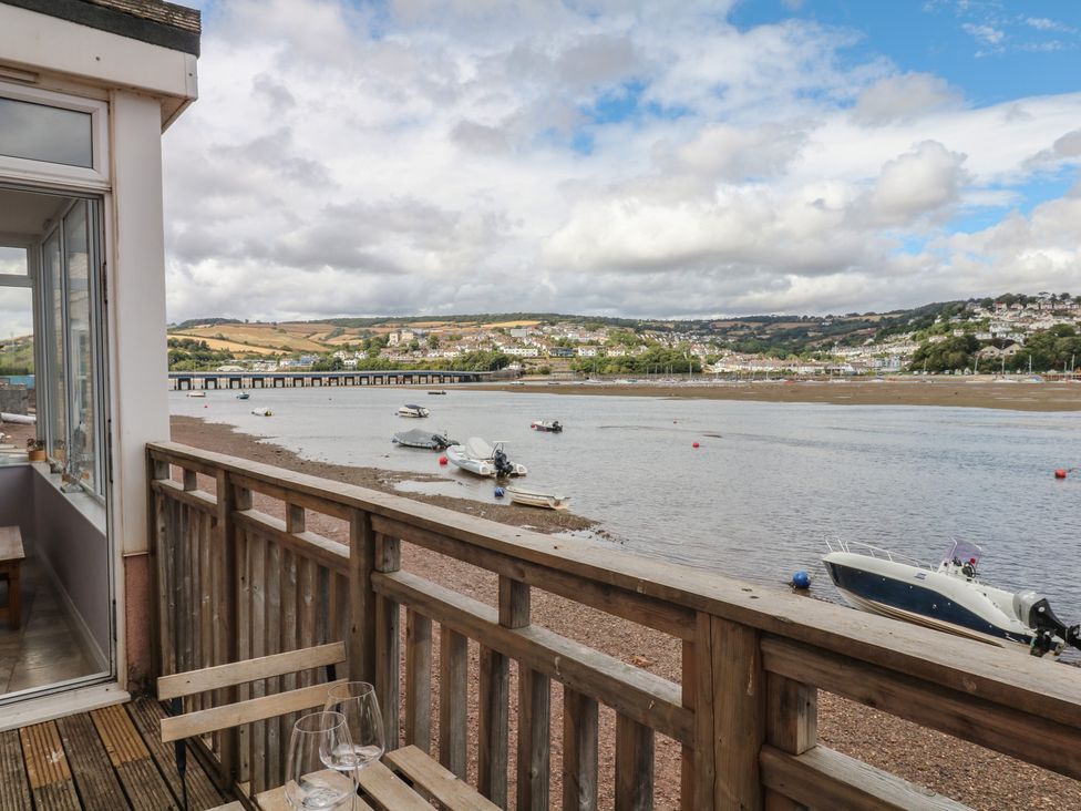 An outdoor deck with a view of the river and boats at The Dolphins in Shaldon