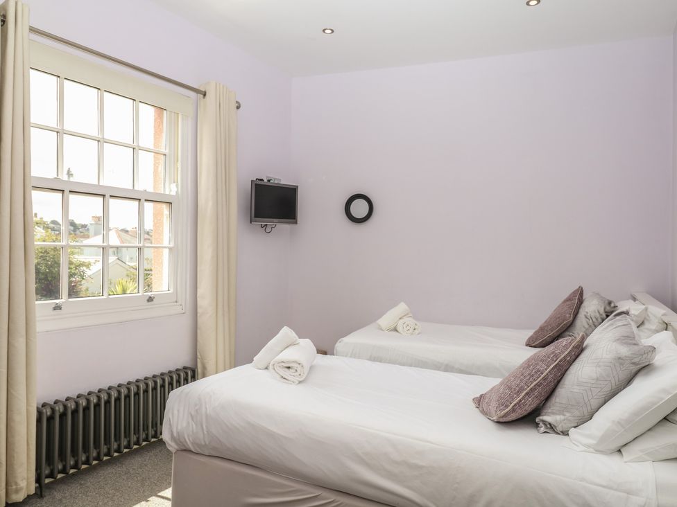 A bedroom with two single beds and a television at The Dolphins in Shaldon