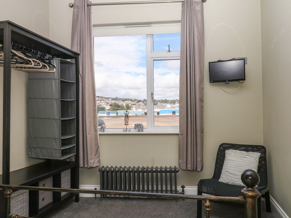 A bedroom with wardrobe and television at The Dolphins in Shaldon