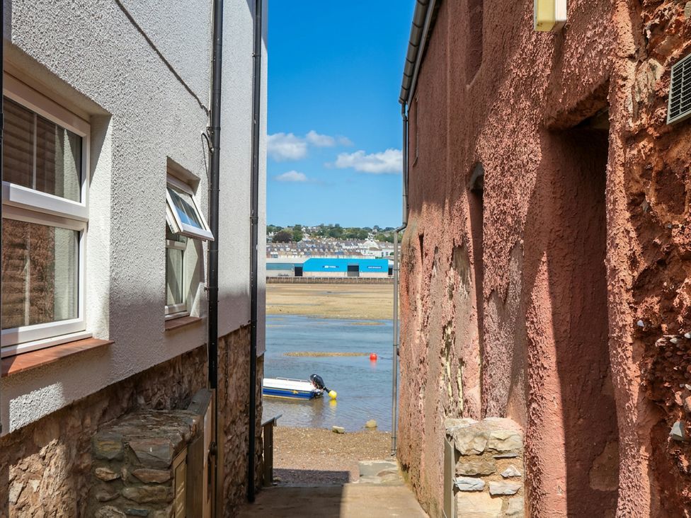 An outdoor view between buildings leading to a boat at The Dolphins in Shaldon
