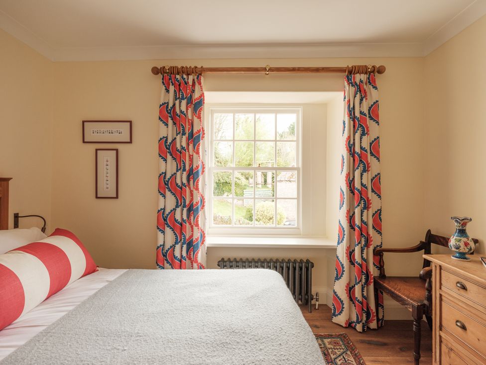 A bedroom with a bed and window at Sandridge Barton Stoke Gabriel
