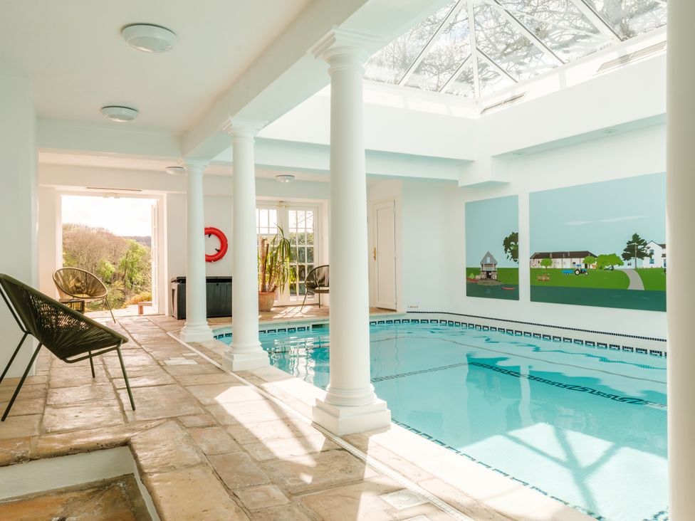 An indoor pool area with columns and artwork at Sandridge Barton Stoke Gabriel