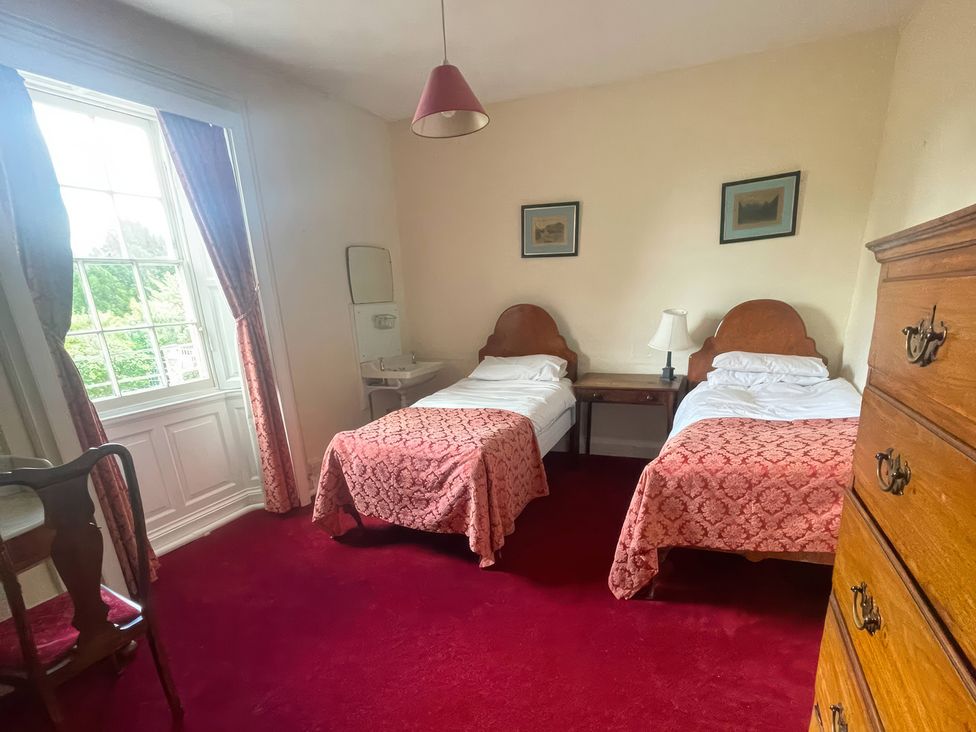A bedroom with two single beds and a table at Wootton House Butleigh Wootton near Compton Dundon