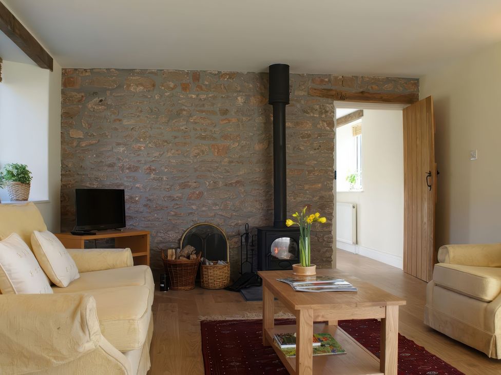 A living room with a television and stove at The Barn in Compton Bishop, near Cheddar