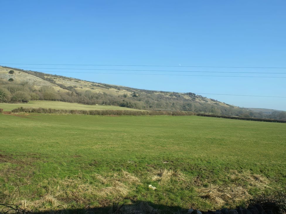 A field with grass and hills under a clear sky at The Barn in Compton Bishop, near Cheddar