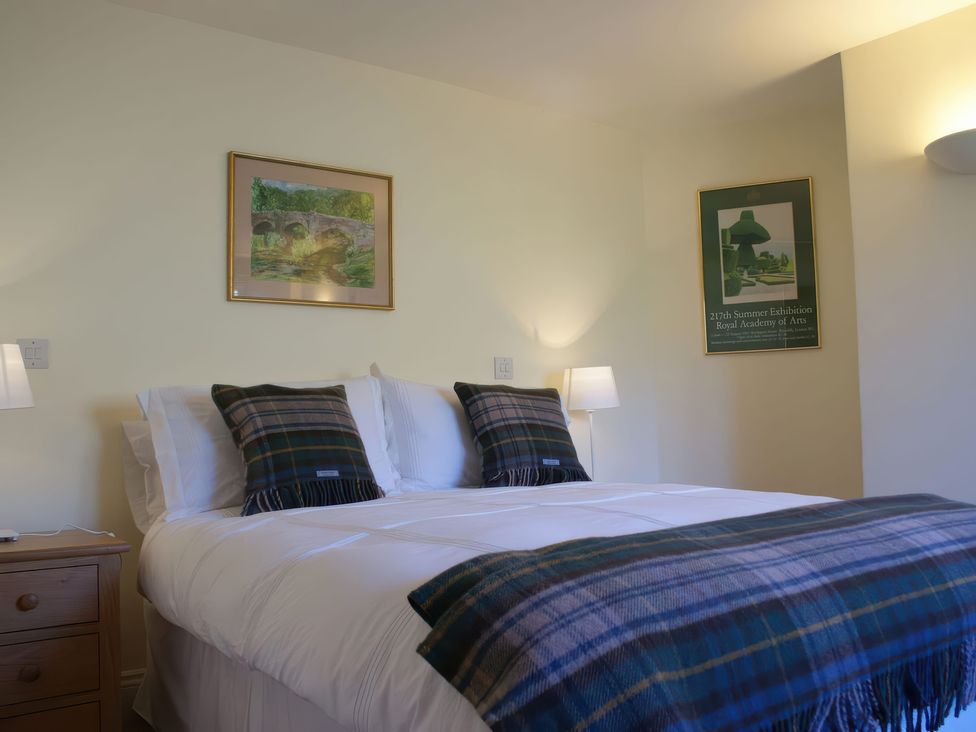 A bedroom with a bed and wall art at The Barn in Compton Bishop, near Cheddar