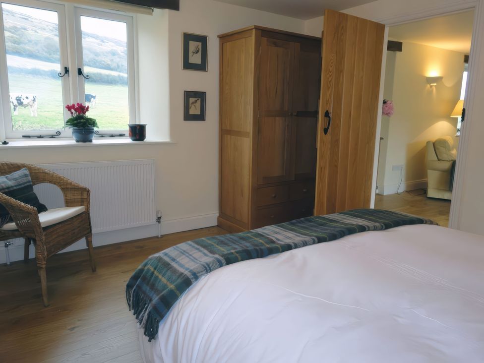 A bedroom with a bed and wardrobe at The Barn in Compton Bishop, near Cheddar