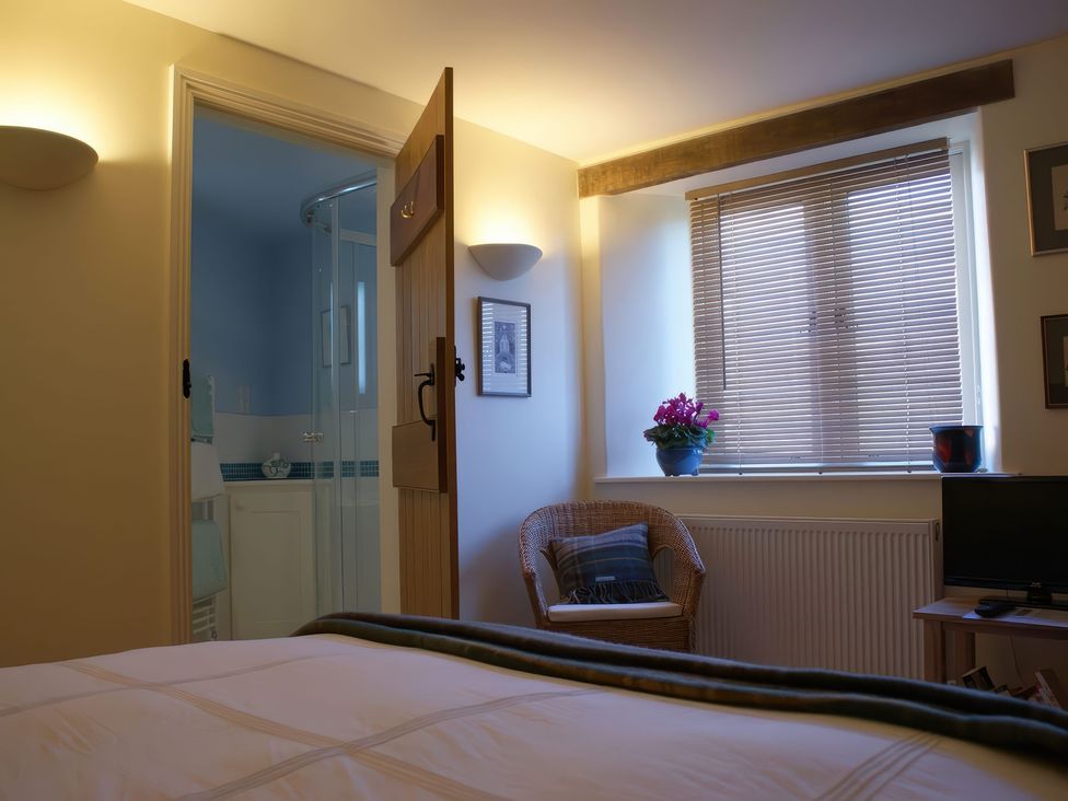 A bedroom with a bed and a window at The Barn in Compton Bishop, near Cheddar