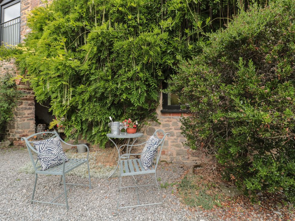 A garden with chairs and a table at The Barn in Compton Bishop, near Cheddar