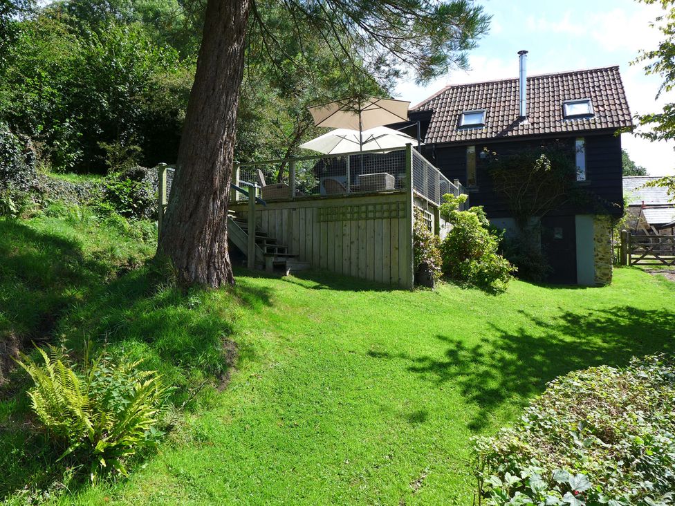 A building with a deck and stairs in a garden at Little Evanses, Dalwood, near Axminster