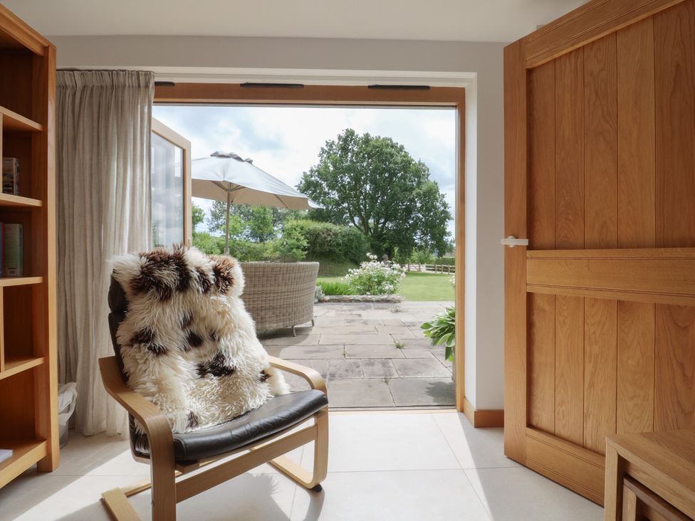 A snug with doors opening to the garden at The Old Log Shed in Honiton