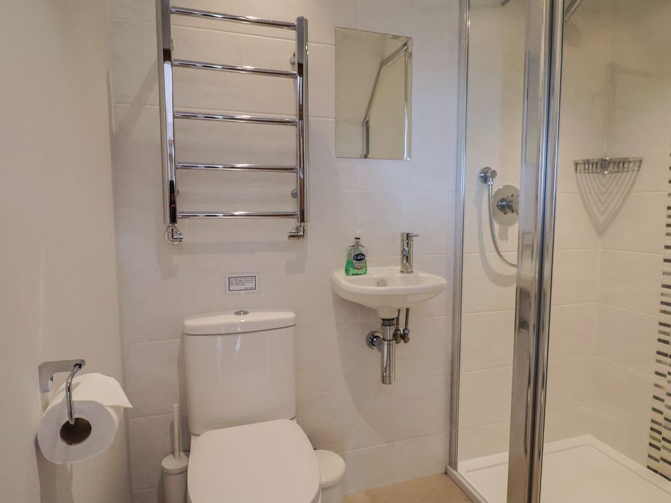 A bathroom with a toilet and washbasin at The Old Log Shed in Honiton