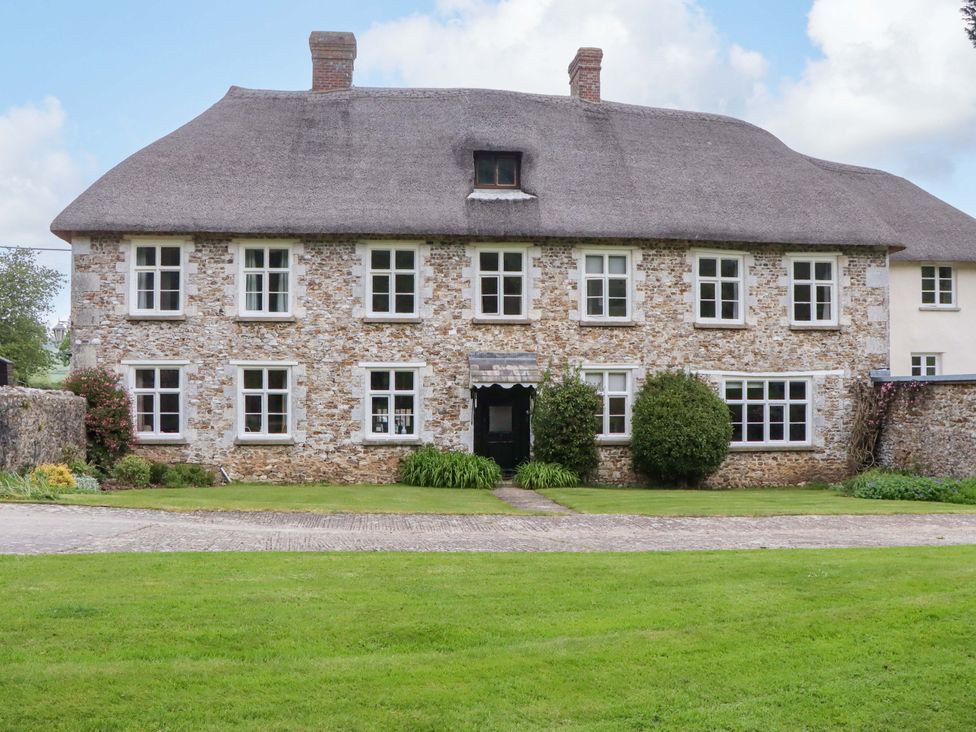 A stone house with a thatched roof at Hornshayne Farmhouse, Farway, near Honiton