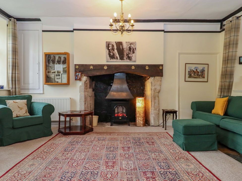 A living room with a fireplace and two sofas at Hornshayne Farmhouse in Farway, near Honiton