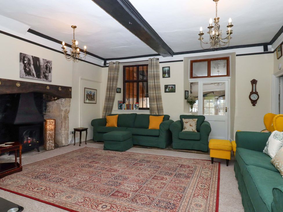 A living room with a fireplace and seating area at Hornshayne Farmhouse Farway, near Honiton
