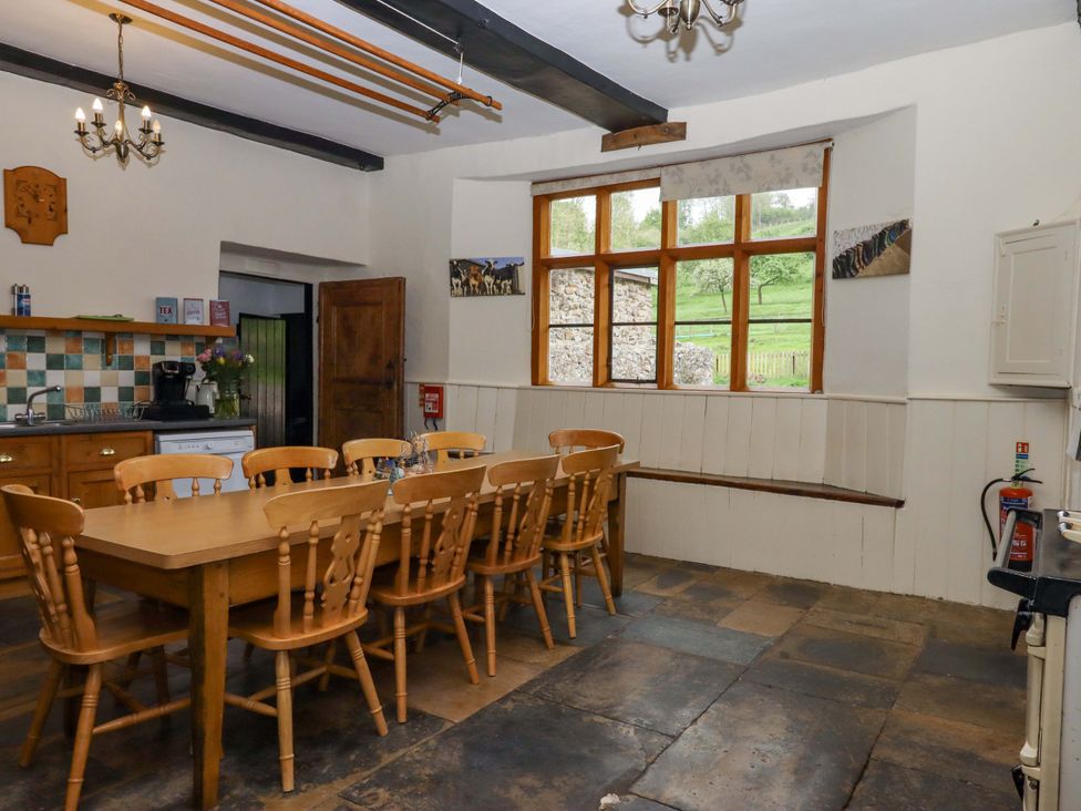 A kitchen with a dining table and chairs at Hornshayne Farmhouse Farway, near Honiton