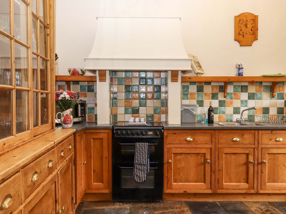 A kitchen with stove and sink at Hornshayne Farmhouse near Honiton