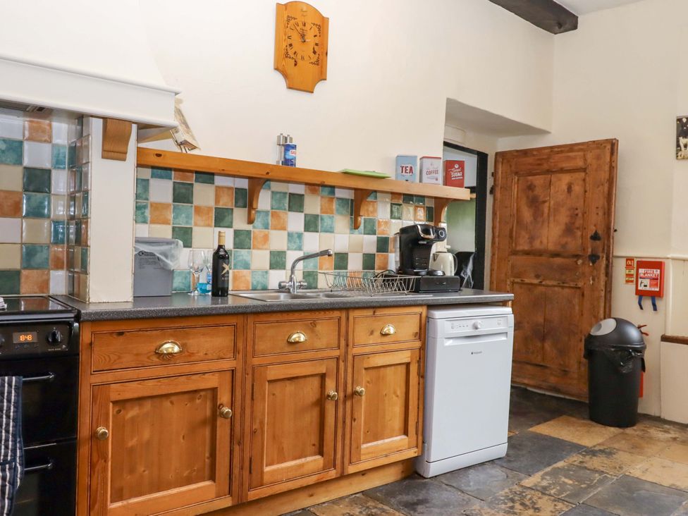 A kitchen with wooden cabinets and appliances at Hornshayne Farmhouse near Honiton