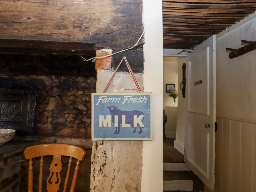 A sign that reads Farm Fresh Milk with a wooden chair at Hornshayne Farmhouse near Honiton