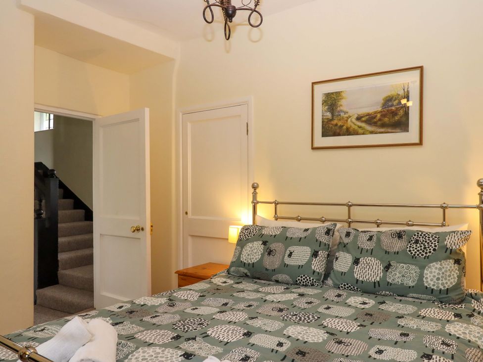 A bedroom with a bed and staircase at Hornshayne Farmhouse, Farway, near Honiton