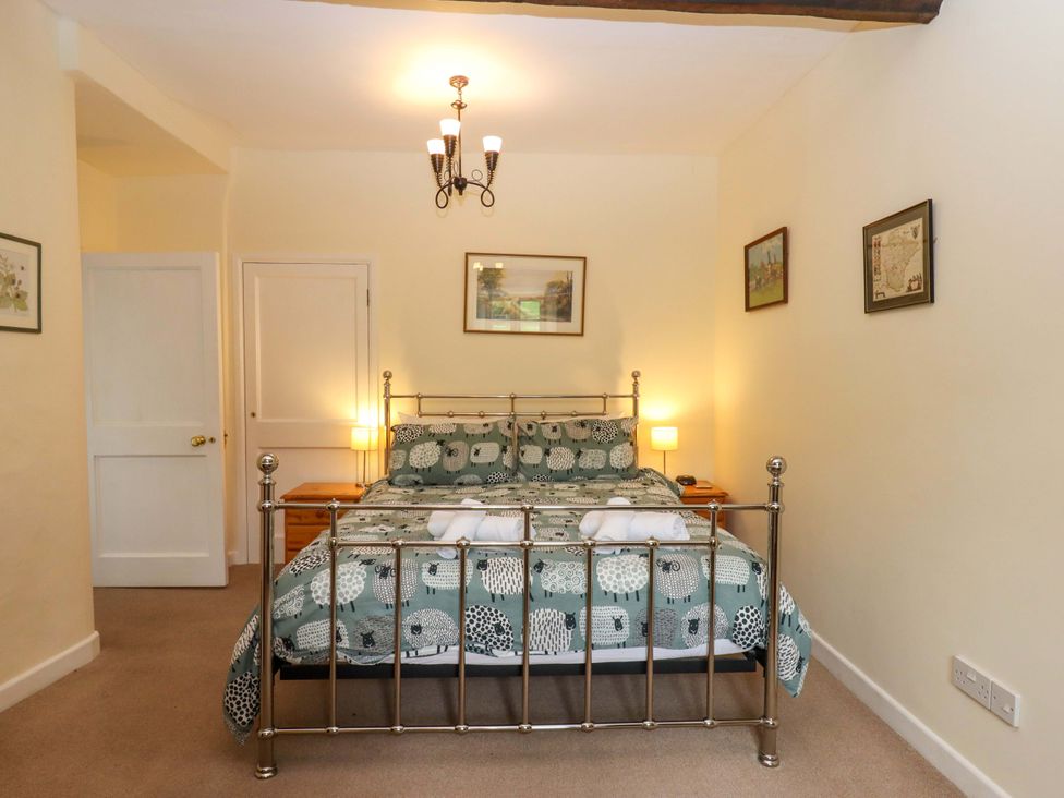 A bedroom with a bed and bedside tables at Hornshayne Farmhouse near Honiton