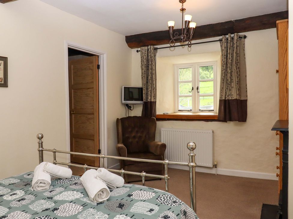 A bedroom with a bed and a chair at Hornshayne Farmhouse Farway, near Honiton