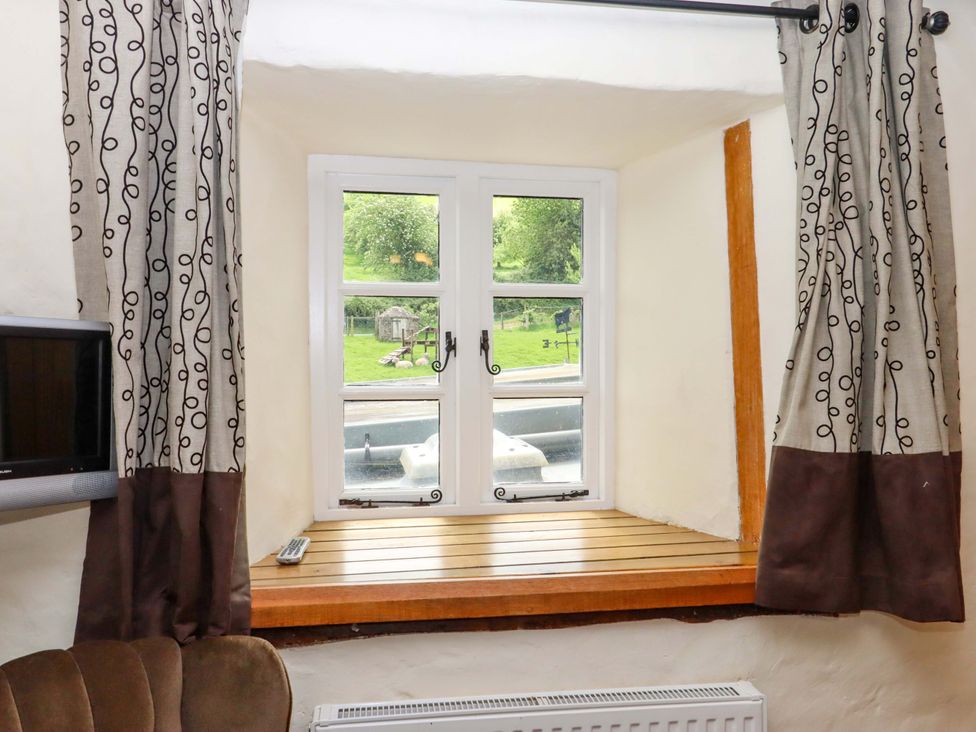 A living room with a window and curtains at Hornshayne Farmhouse, Farway, near Honiton