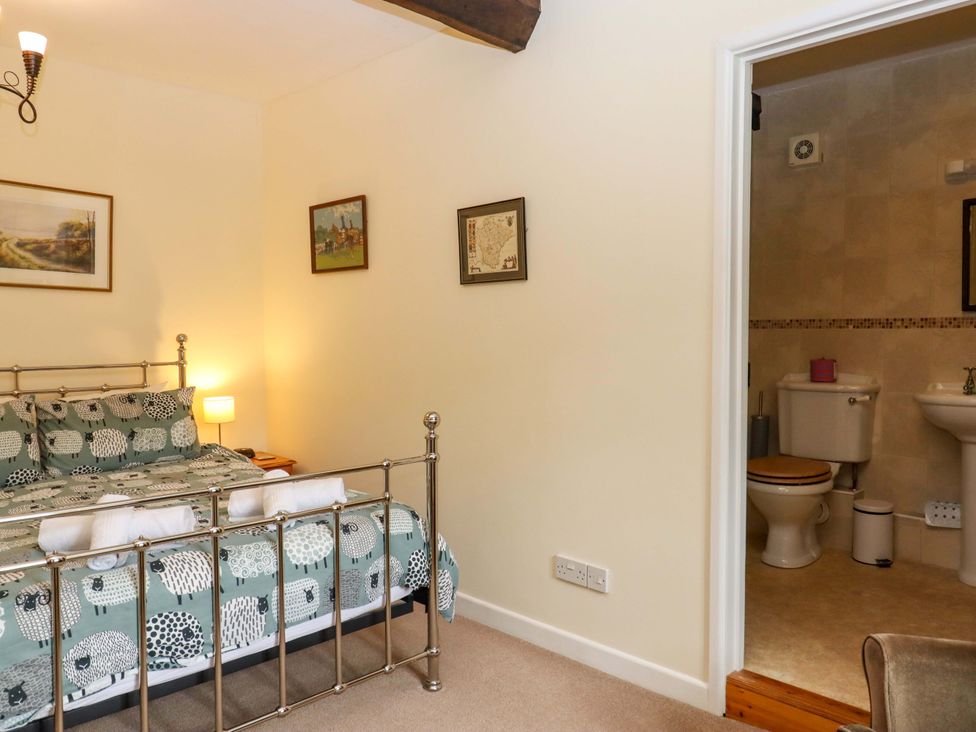 A bedroom with a bed and adjoining bathroom at Hornshayne Farmhouse, Farway, near Honiton