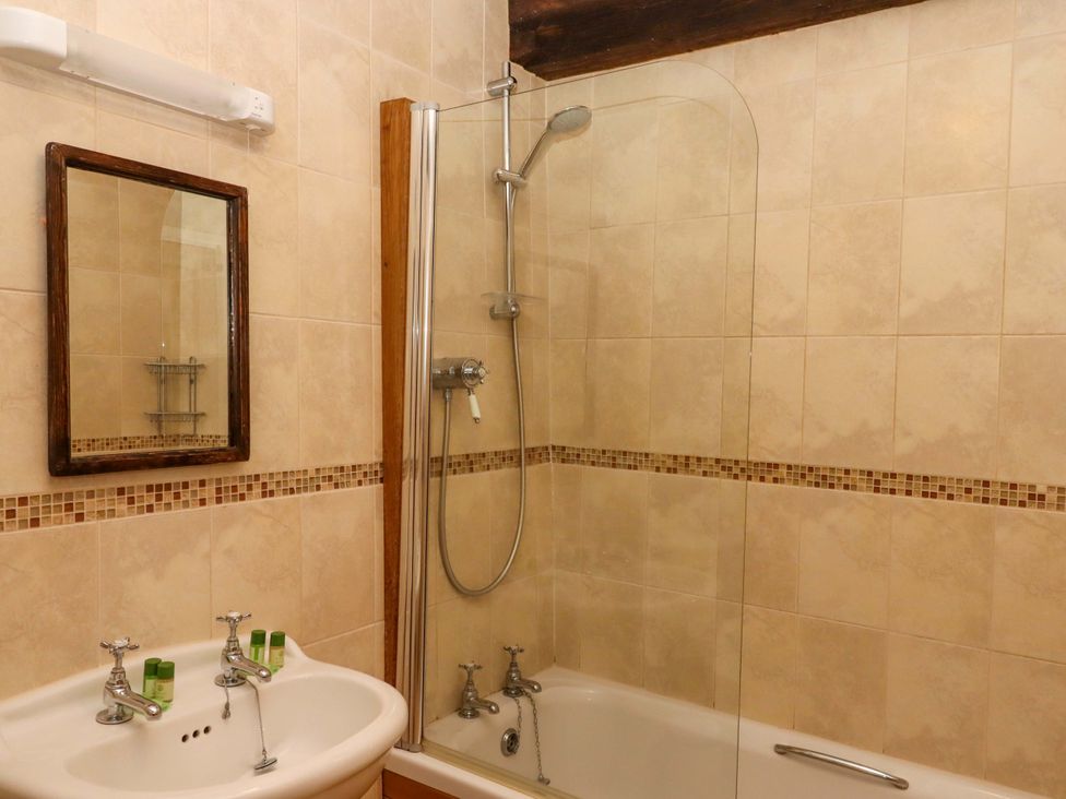 A bathroom with a bathtub and shower at Hornshayne Farmhouse Farway, near Honiton