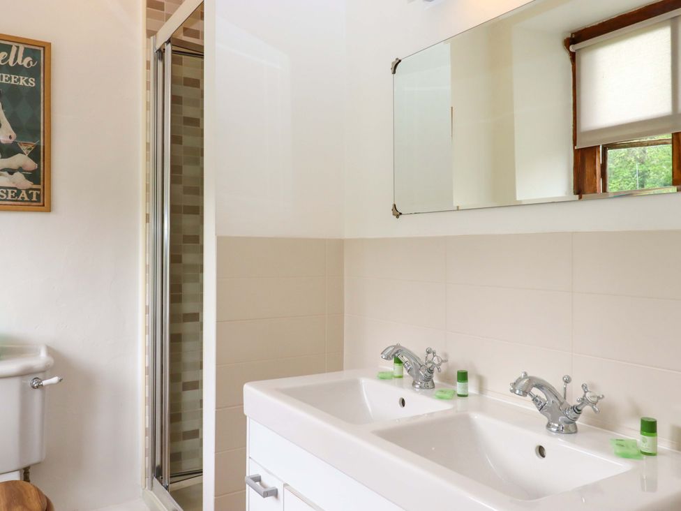A bathroom with a double sink and shower enclosure at Hornshayne Farmhouse near Honiton