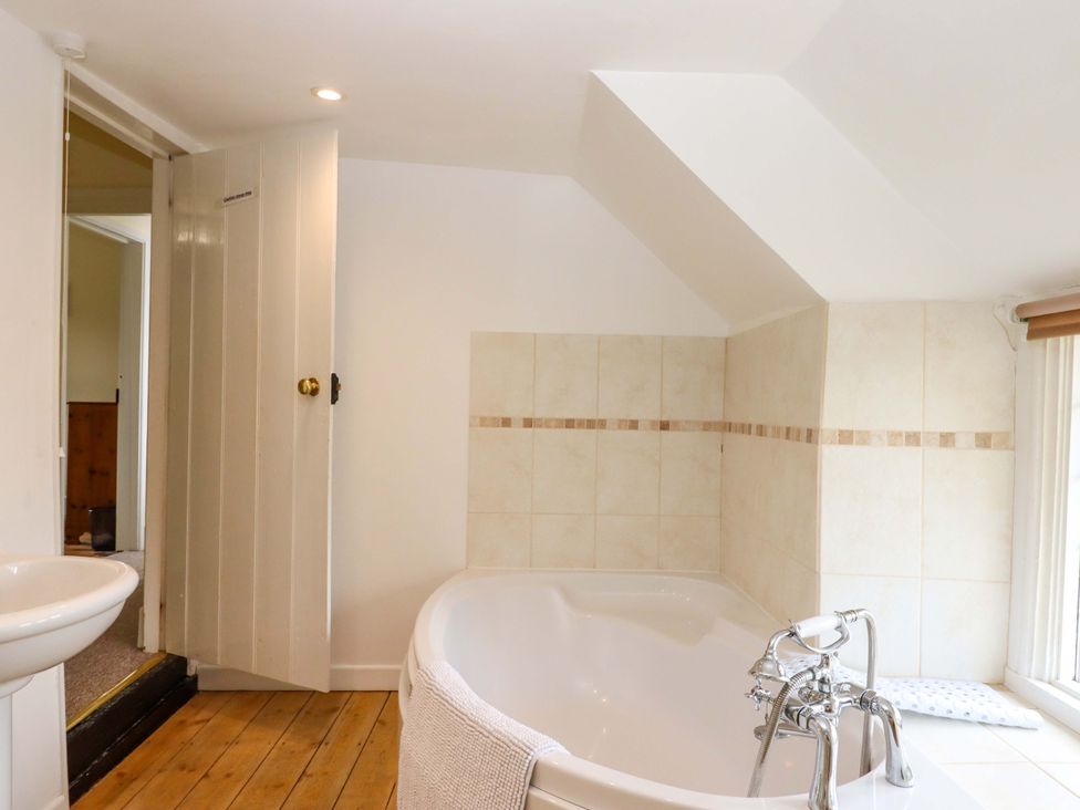 A bathroom with a bathtub and sink at Hornshayne Farmhouse, Farway, near Honiton