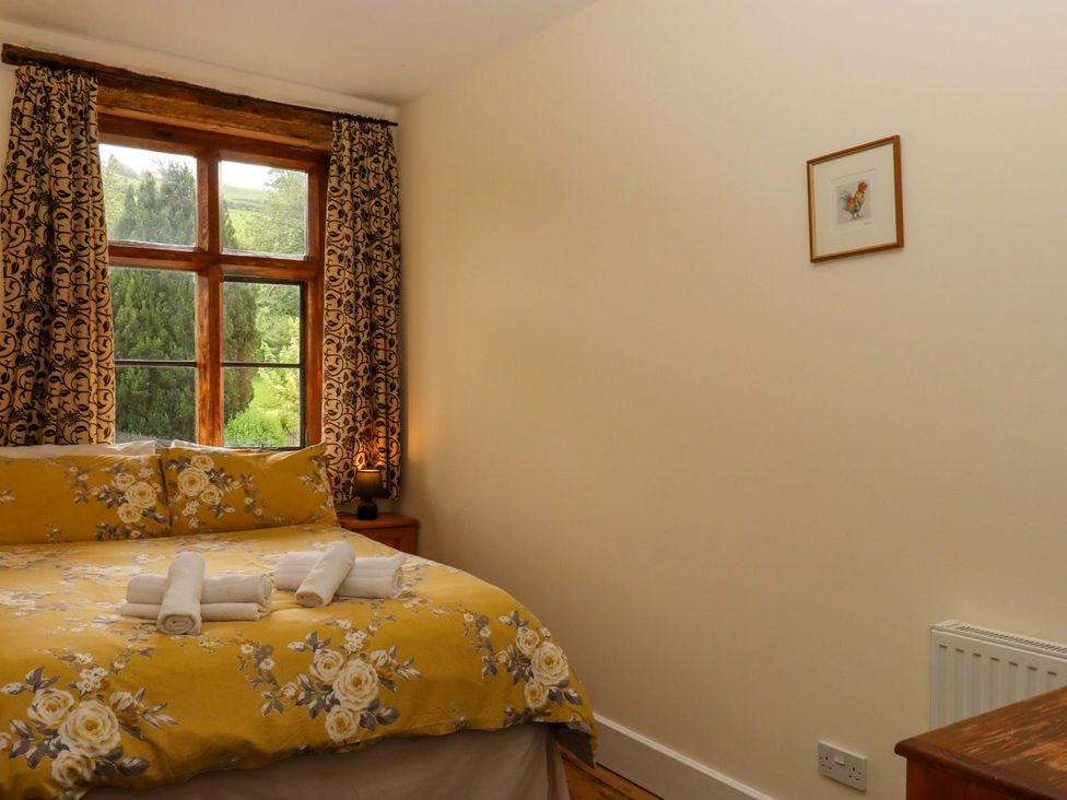A bedroom with a bed and window at Hornshayne Farmhouse, Farway, near Honiton