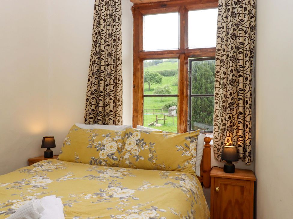 A bedroom with a bed and window at Hornshayne Farmhouse, Farway, near Honiton