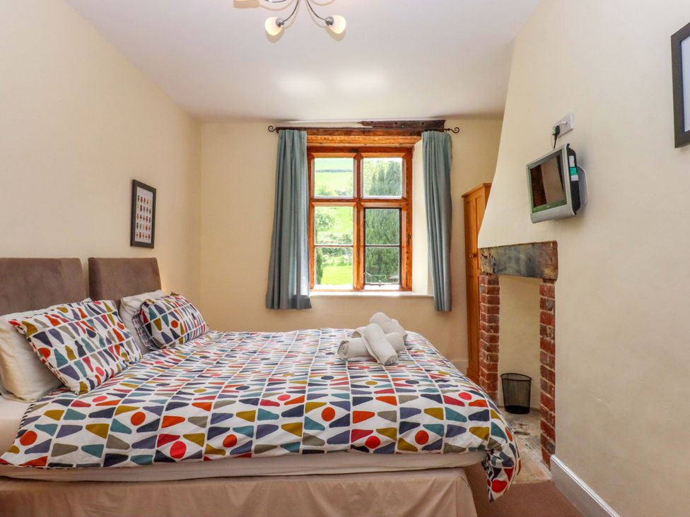 A bedroom with a bed and a window at Hornshayne Farmhouse, Farway, near Honiton