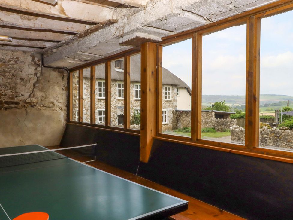 A games room with a ping pong table and a view of the countryside at Hornshayne Farmhouse in Farway, near Honiton