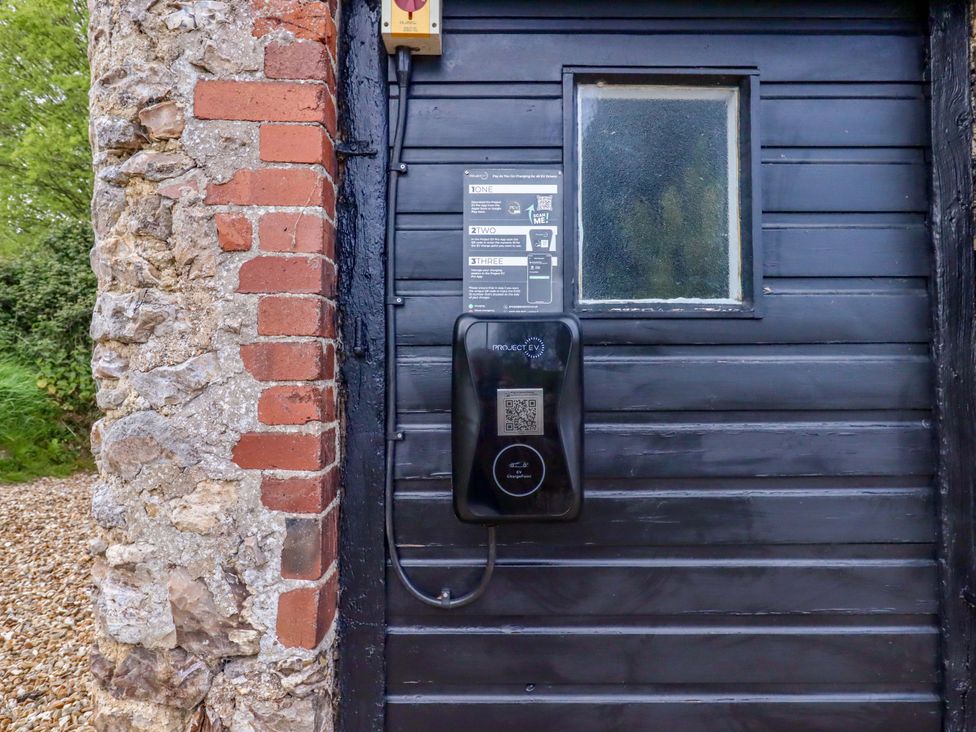 An exterior wall with a charging station and a window at Hornshayne Farmhouse Farway near Honiton