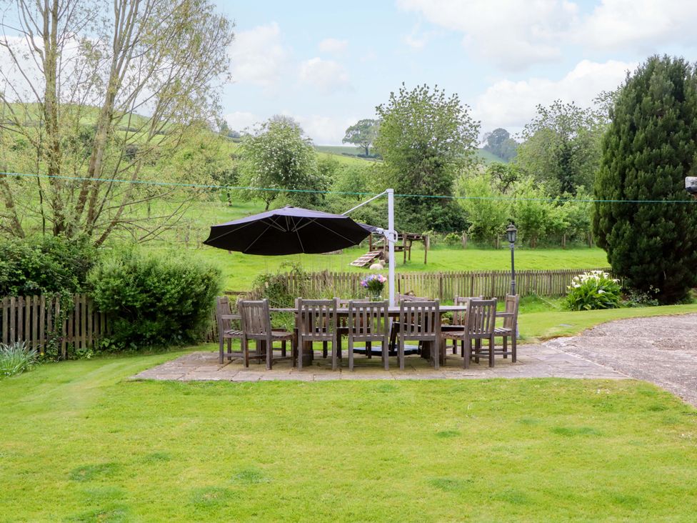 A garden with a dining table and chairs at Hornshayne Farmhouse, Farway, near Honiton
