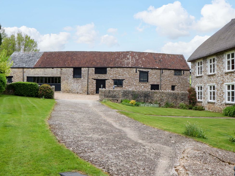 An outdoor view of a barn and house at Hornshayne Farmhouse in Farway, near Honiton