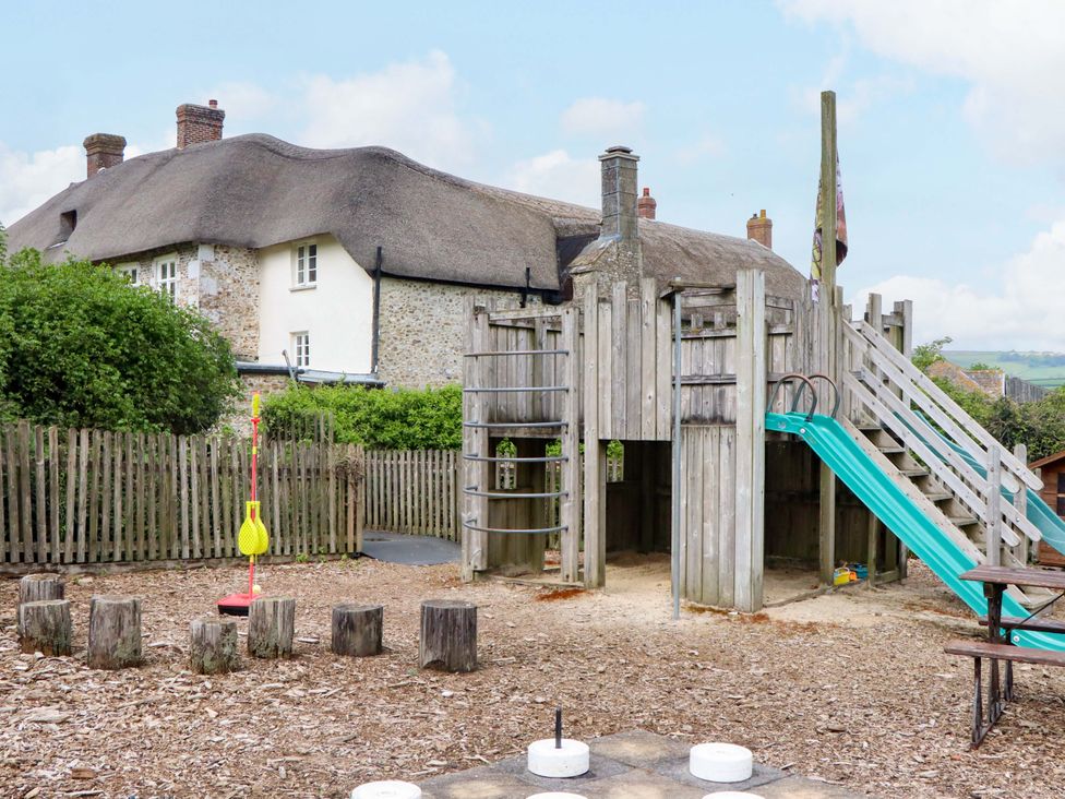 A playground with a slide and climbing structure at Hornshayne Farmhouse, Farway, near Honiton