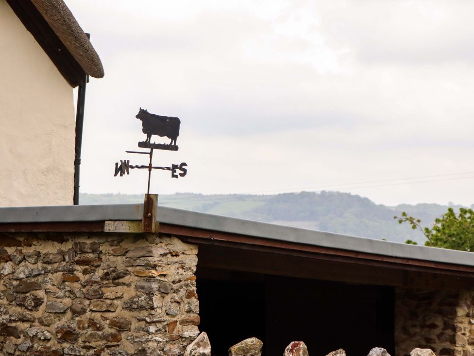 A weather vane in the shape of a cow on a building at Hornshayne Farmhouse Farway, near Honiton